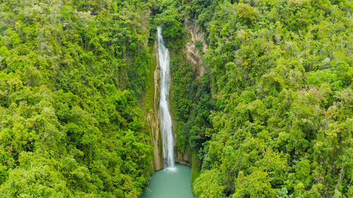 Beautiful waterfall in green forest, top view. tropical mantayupan falls in mountain jungle