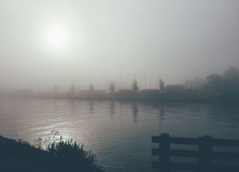 Scenic view of lake against sky during foggy weather