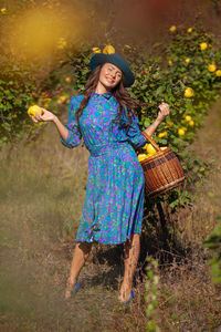 Portrait of smiling woman with fruits standing on land