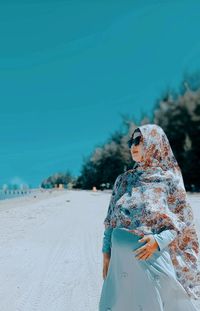 Portrait of woman standing at beach