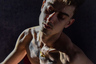 Portrait of young man against black background