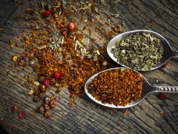 Close-up of seasoning in spoons on wooden cutting board