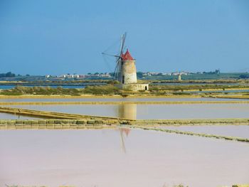 View of windmill on landscape against clear sky