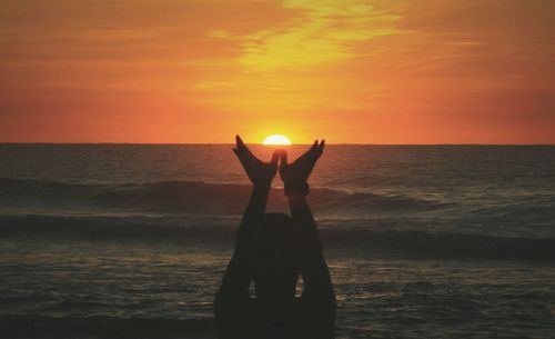 Silhouette man at beach during sunset