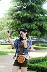 Young happy business woman relaxing in city, park. using phone. selfie. technology. summer vacation