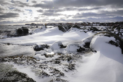 Scenic view of frozen beach against sky