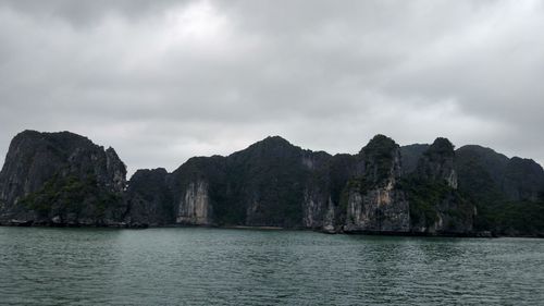 Scenic view of mountains and sea against cloudy sky