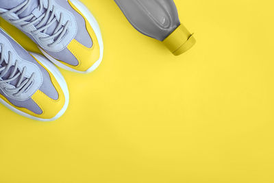 High angle view of shoes on yellow background