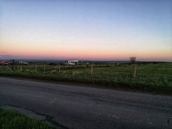 Scenic view of field against clear sky during sunset