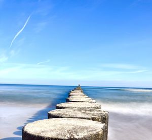 Scenic view of sea against sky. wooden breakwater. long exposure