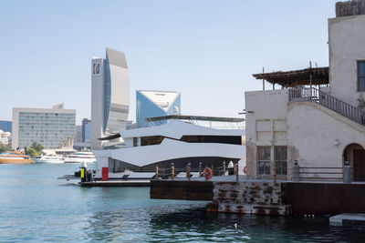 Buildings by sea against clear sky