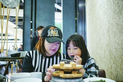 Mother and daughter sitting at restaurant