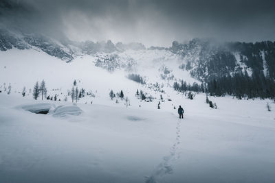 People skiing on snow covered mountain against sky