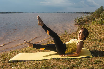 Woman relaxing on land against sky