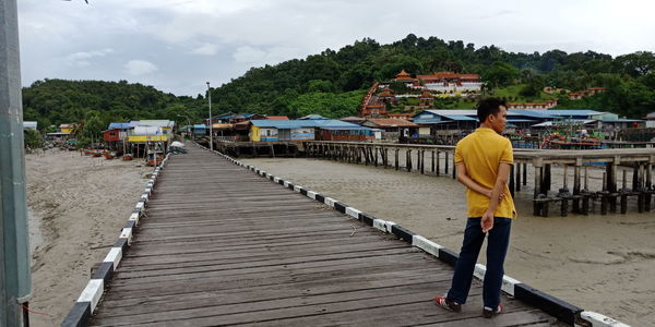 Rear view of man standing on pier