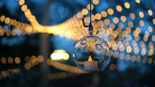 Beautiful evening garden party glass ornaments with candle bokeh of festive light background
