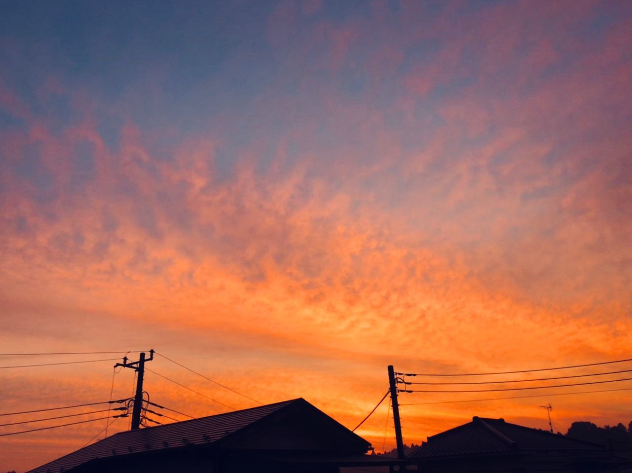 SILHOUETTE HOUSES AGAINST ORANGE SKY