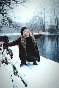 Full length of woman on snow covered tree during winter