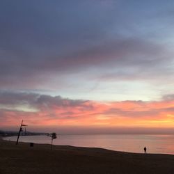 Silhouette of beach against cloudy sky