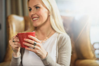 Cheerful female resting in armchair in cafe