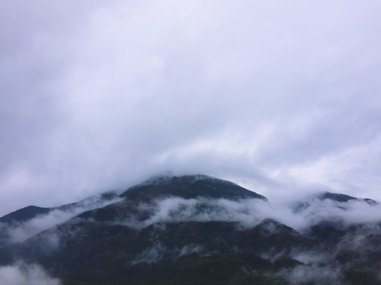 sky, scenics, tranquil scene, tranquility, mountain, beauty in nature, cloud - sky, weather, cloudy, nature, mountain range, cloudscape, idyllic, cloud, overcast, fog, majestic, landscape, day, outdoors