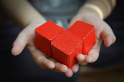 Close-up of child's hands holding red blocks