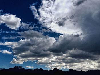 Low angle view of mountain range against cloudy sky