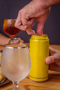 Midsection of man holding wine glass on table