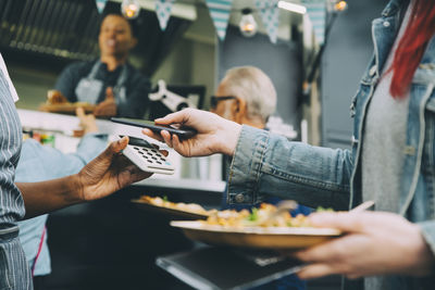 People holding food in restaurant