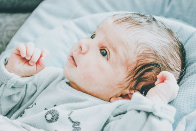 Portrait of cute baby lying on bed