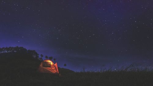 Scenic view of tent on field against sky at night