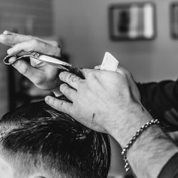 Cropped image of hairdresser hand cutting hair