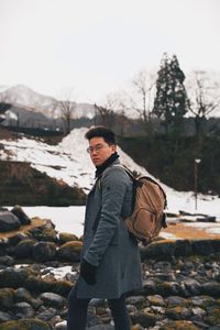 Young man standing on field against sky