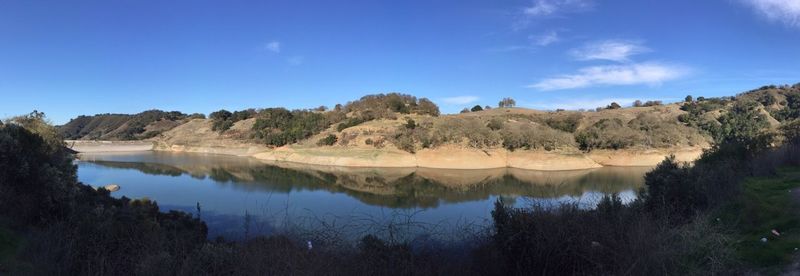 Panoramic view of landscape against blue sky