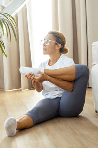 Young woman sitting on sofa at home