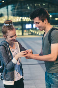 Young man and woman standing in city