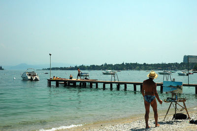 People standing on beach against clear sky