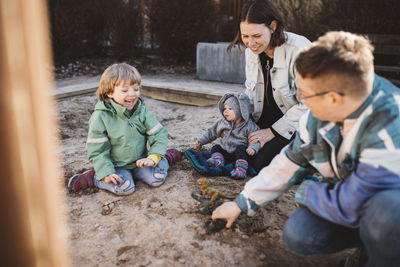Family with children playing in sandpit