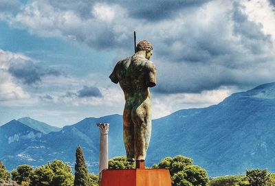 Statue against trees and mountains against sky