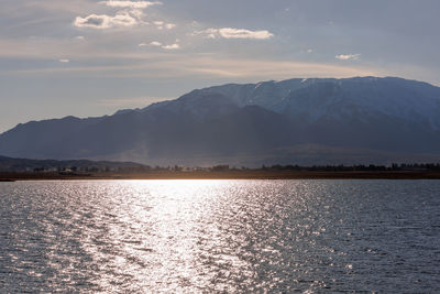 Scenic view of sea and mountains against sky