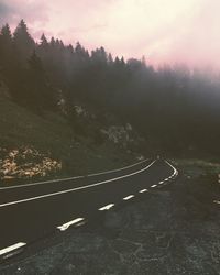 Road by trees against sky