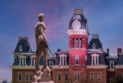 Low angle view of statue against building and sky