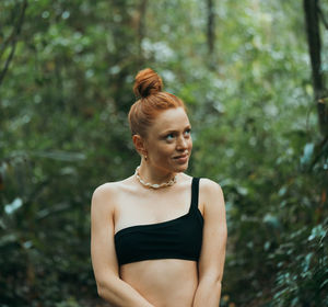 Young woman looking up in forest