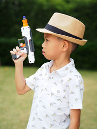 Close-up of boy holding hat