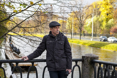 Portrait of man standing by railing