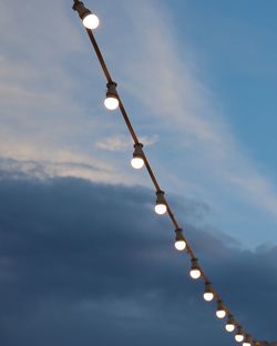 Low angle view of illuminated street light against sky