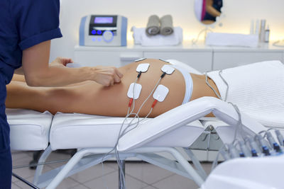 Midsection of woman lying down on bed