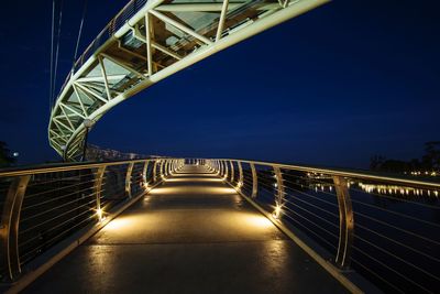 Illuminated footbridge against sky at night