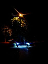 Cars on illuminated street at night