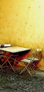 Abandoned chairs against wall